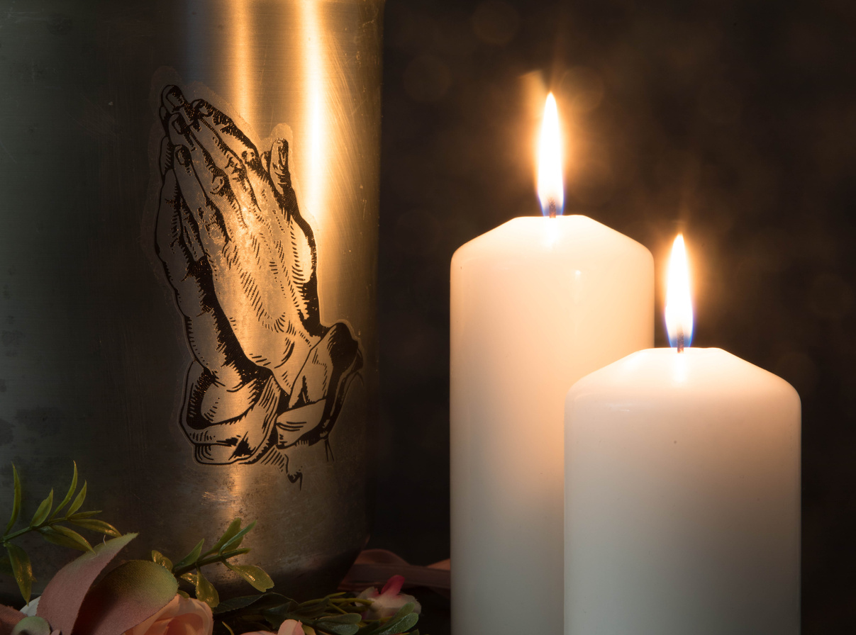 Funeral mourning urn with burning candles for obituary.